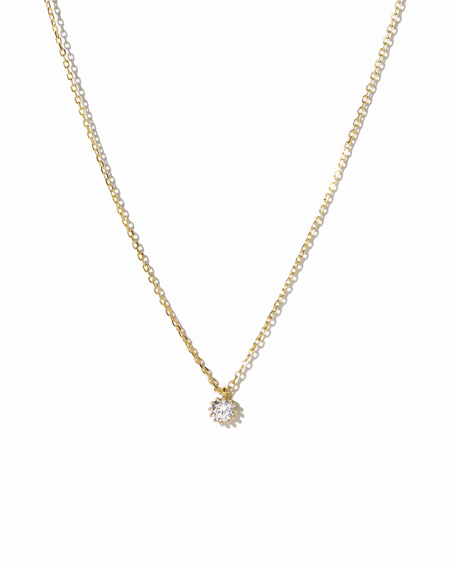 dainty gold tiny bezel pendant necklace on white background