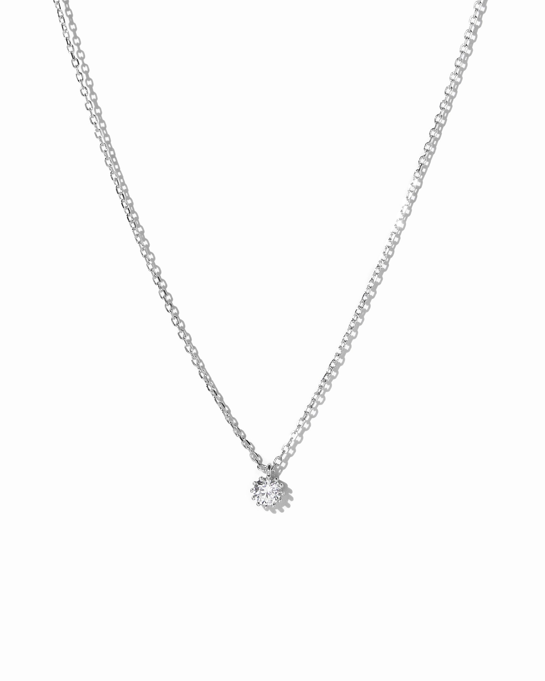 Silver round tiny bezel pendant necklace on white background