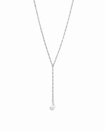 Delicate silver pearl lariat necklace on white background.