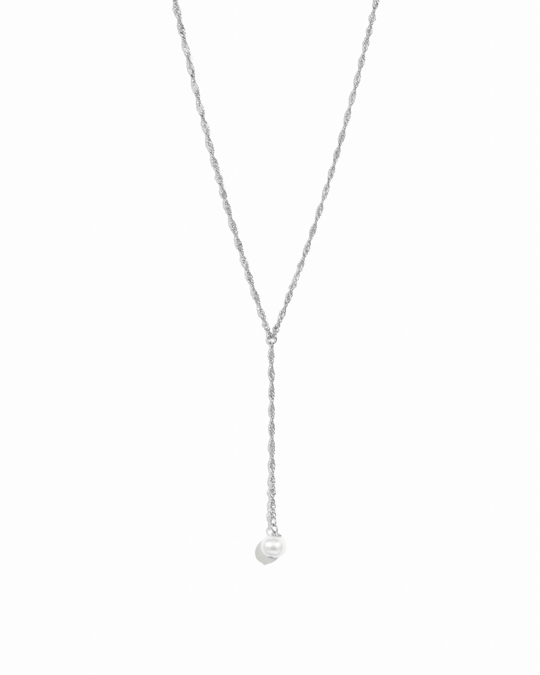 Delicate silver pearl lariat necklace on white background.