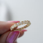 Model holding statement 3MM studded gold diamond eternity ring. 