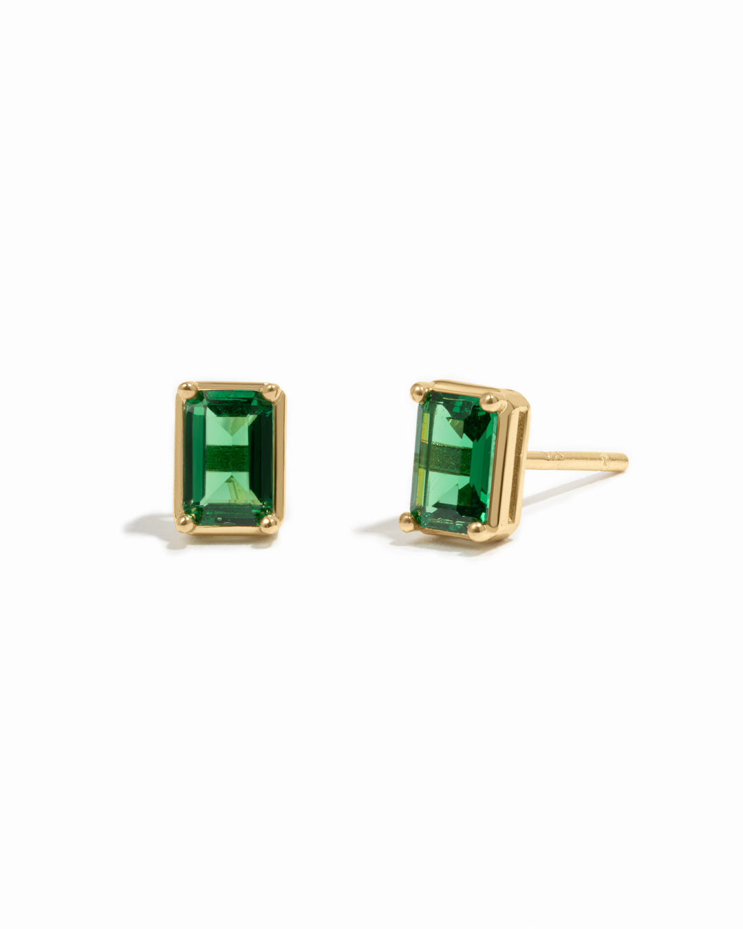 Gold emerald-cut emerald gemstone stud earrings.
