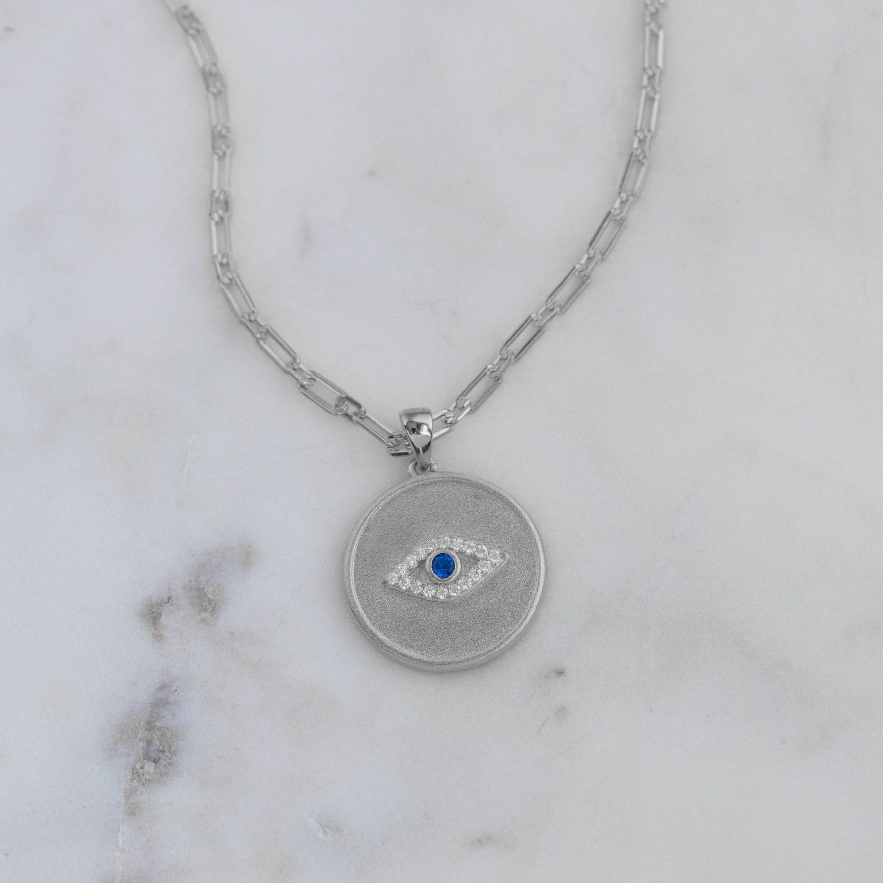 Sterling silver evil eye medallion circle pendant necklace on paperclip chain.