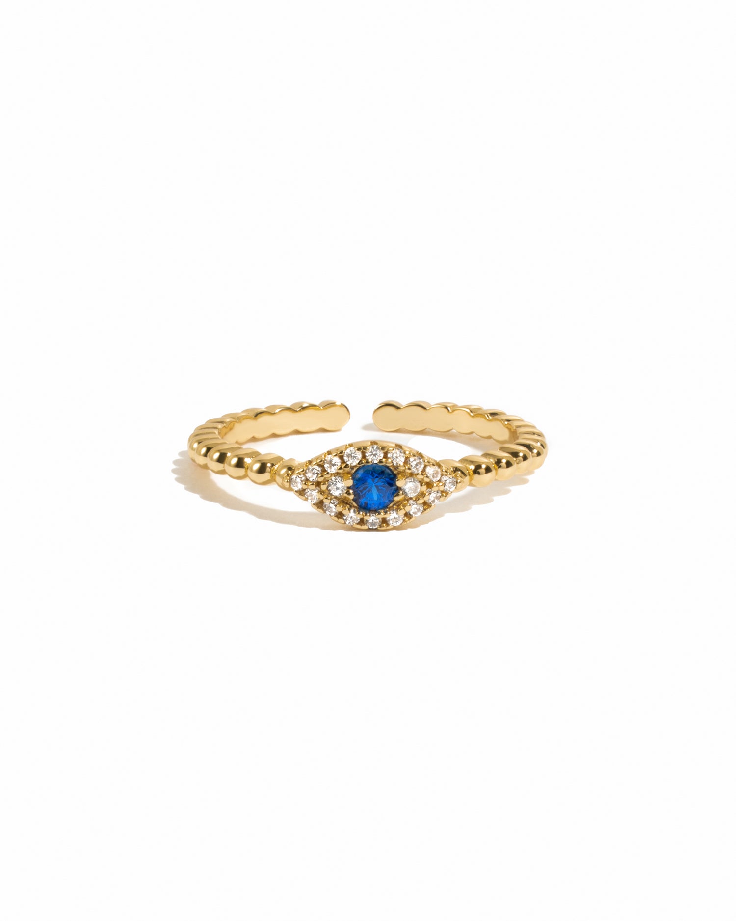 Dainty gold beaded adjustable evil eye ring with sapphire center on white background. 