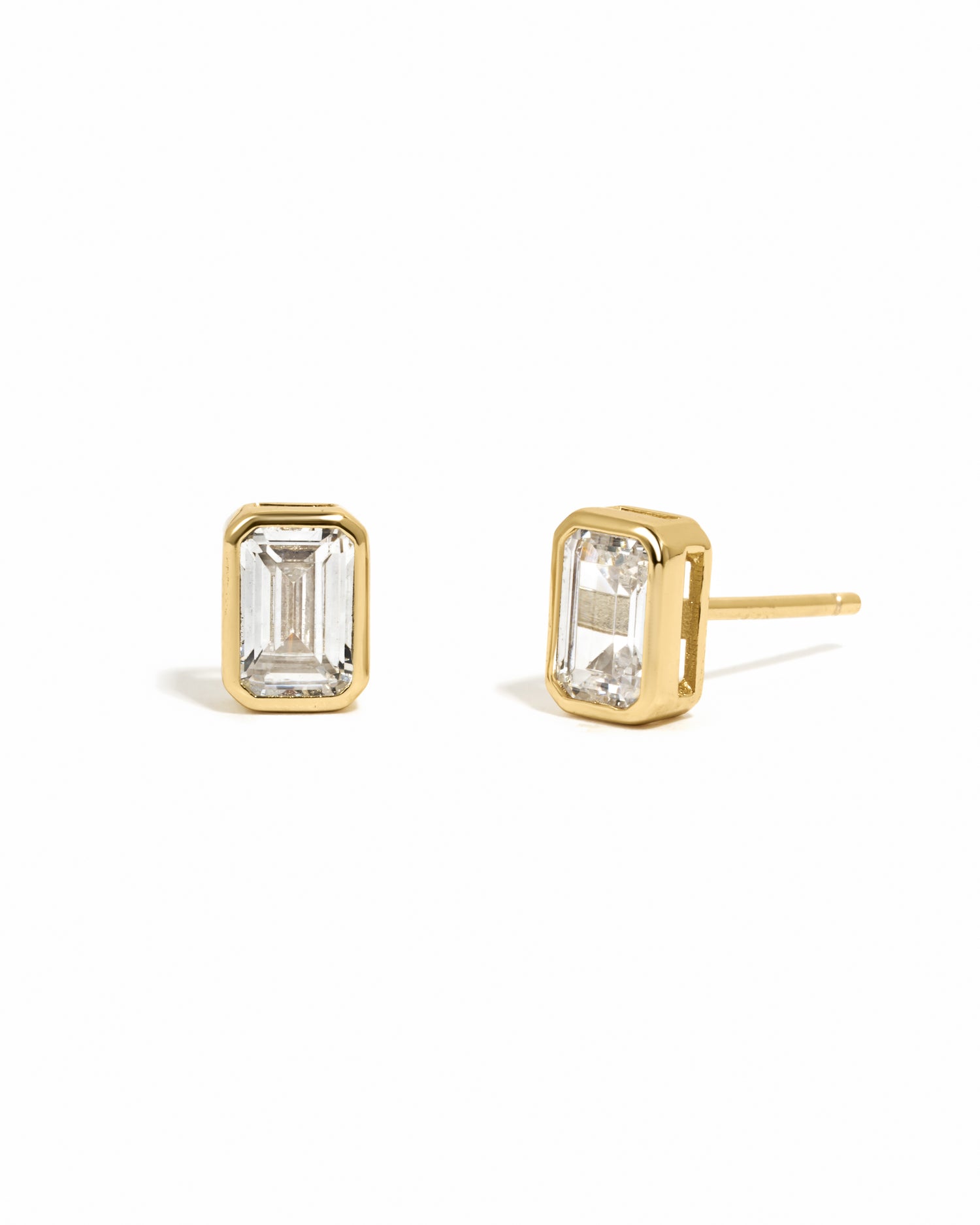 Gold emerald-cut bezel diamond cz stud earrings on white background.