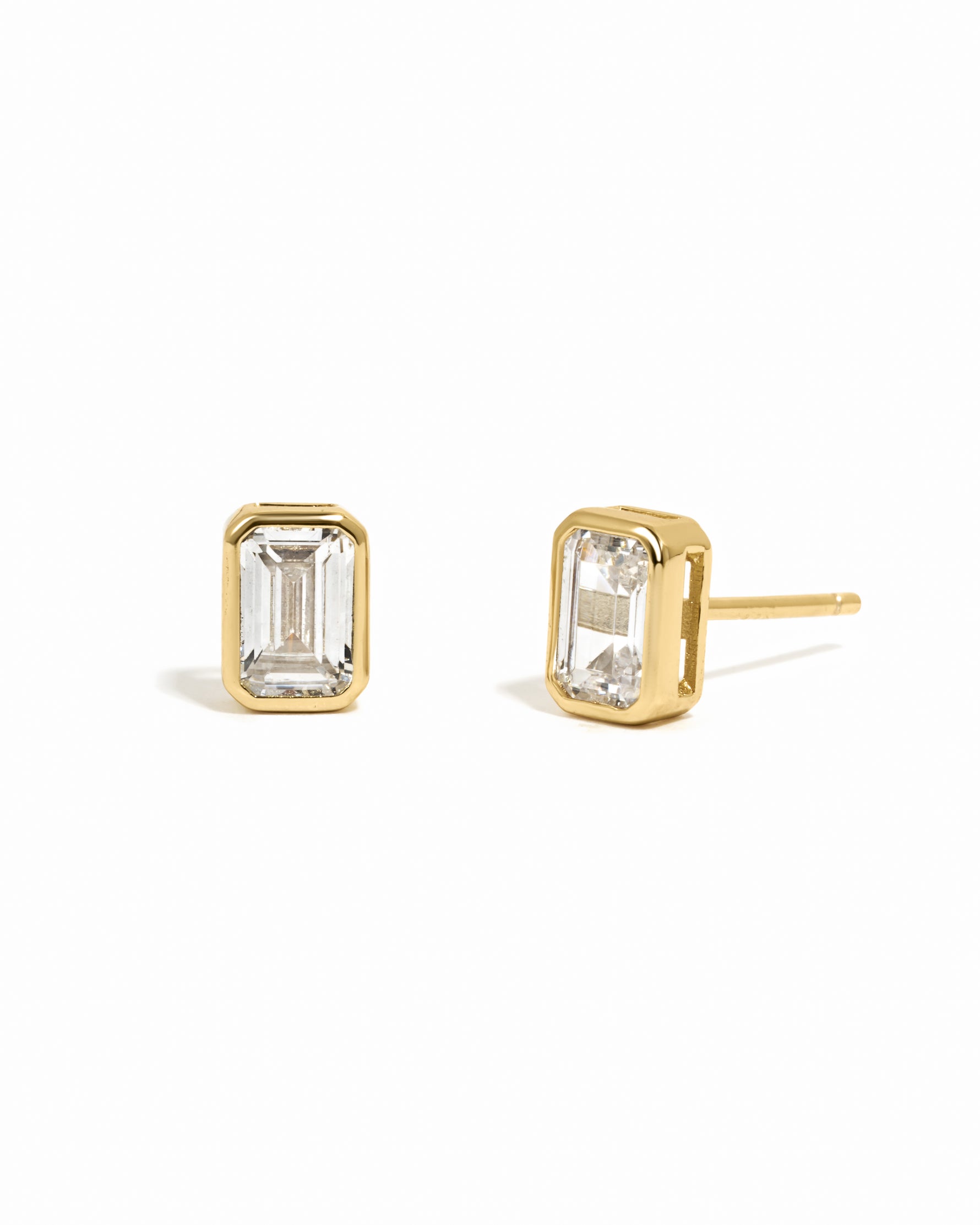 Gold emerald-cut bezel diamond cz stud earrings on white background.
