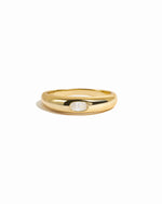 Gold oval cz bezeled dome ring on white background.