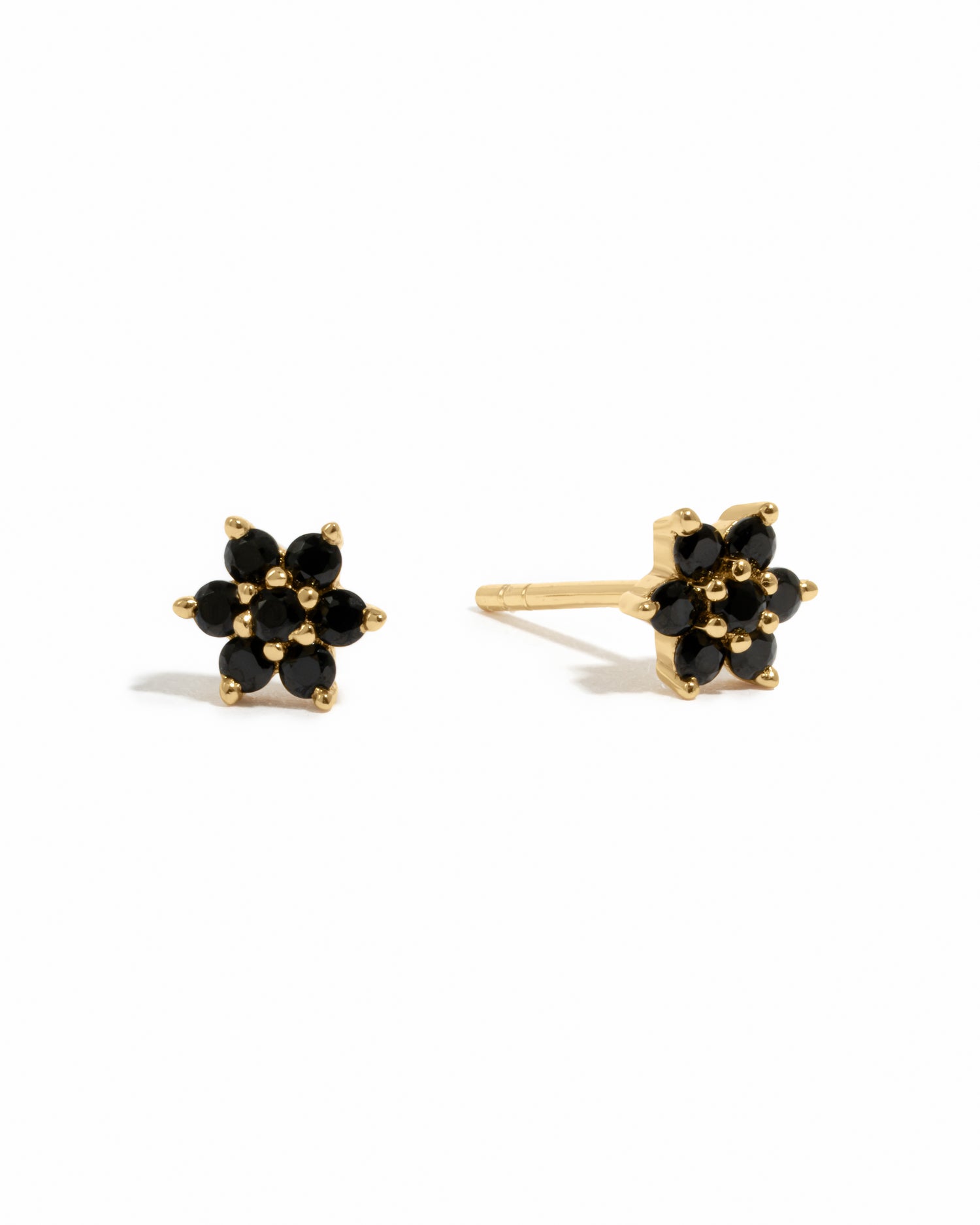 Gold delicate black onyx gemstone flower stud earrings on white background.