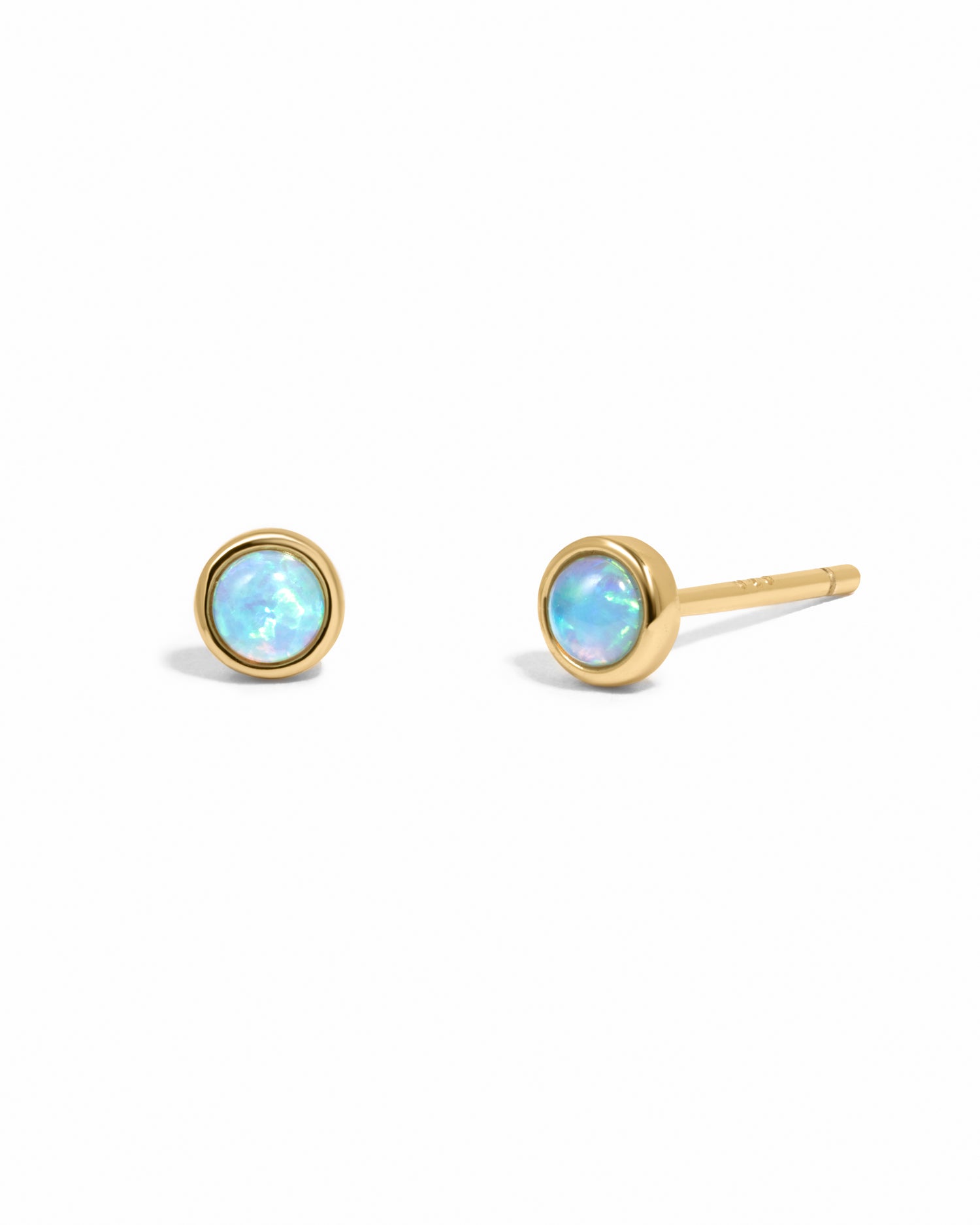 Gold vibrant blue opal stud earrings on white background.