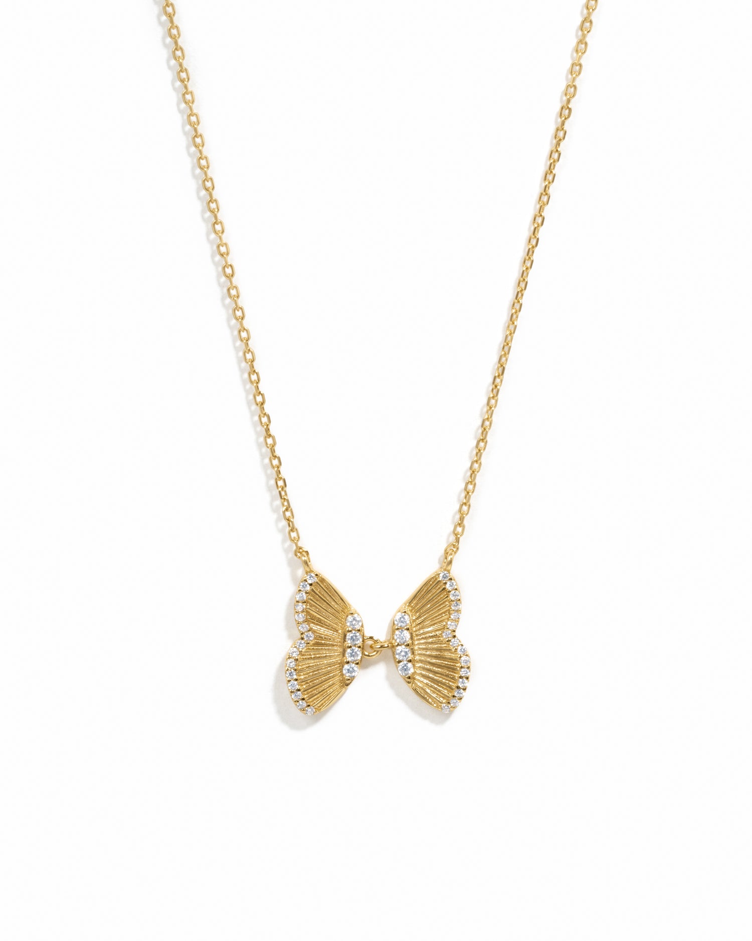 Statement gold butterfly pendant with cz stones on white background