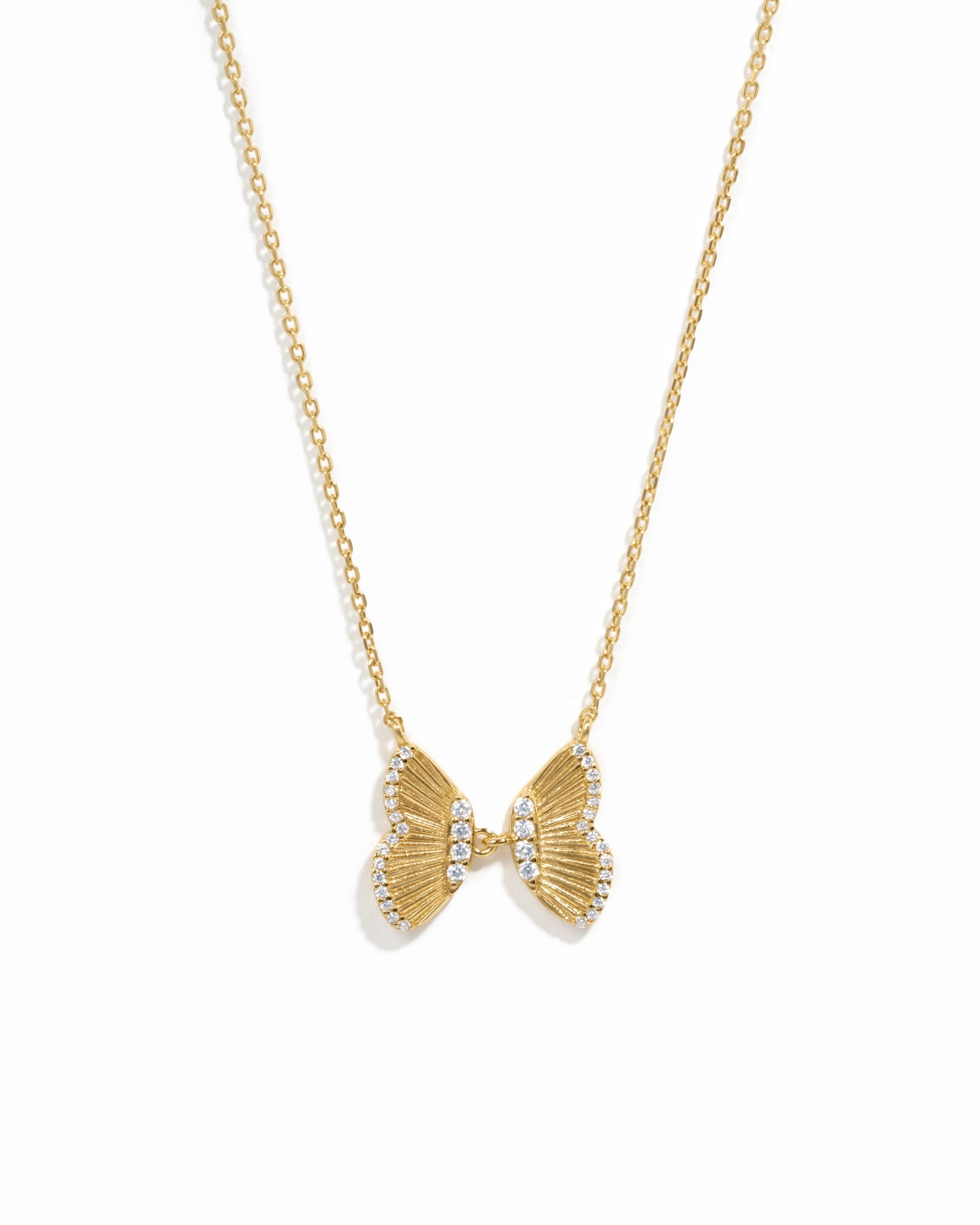 Statement gold butterfly pendant with cz stones on white background