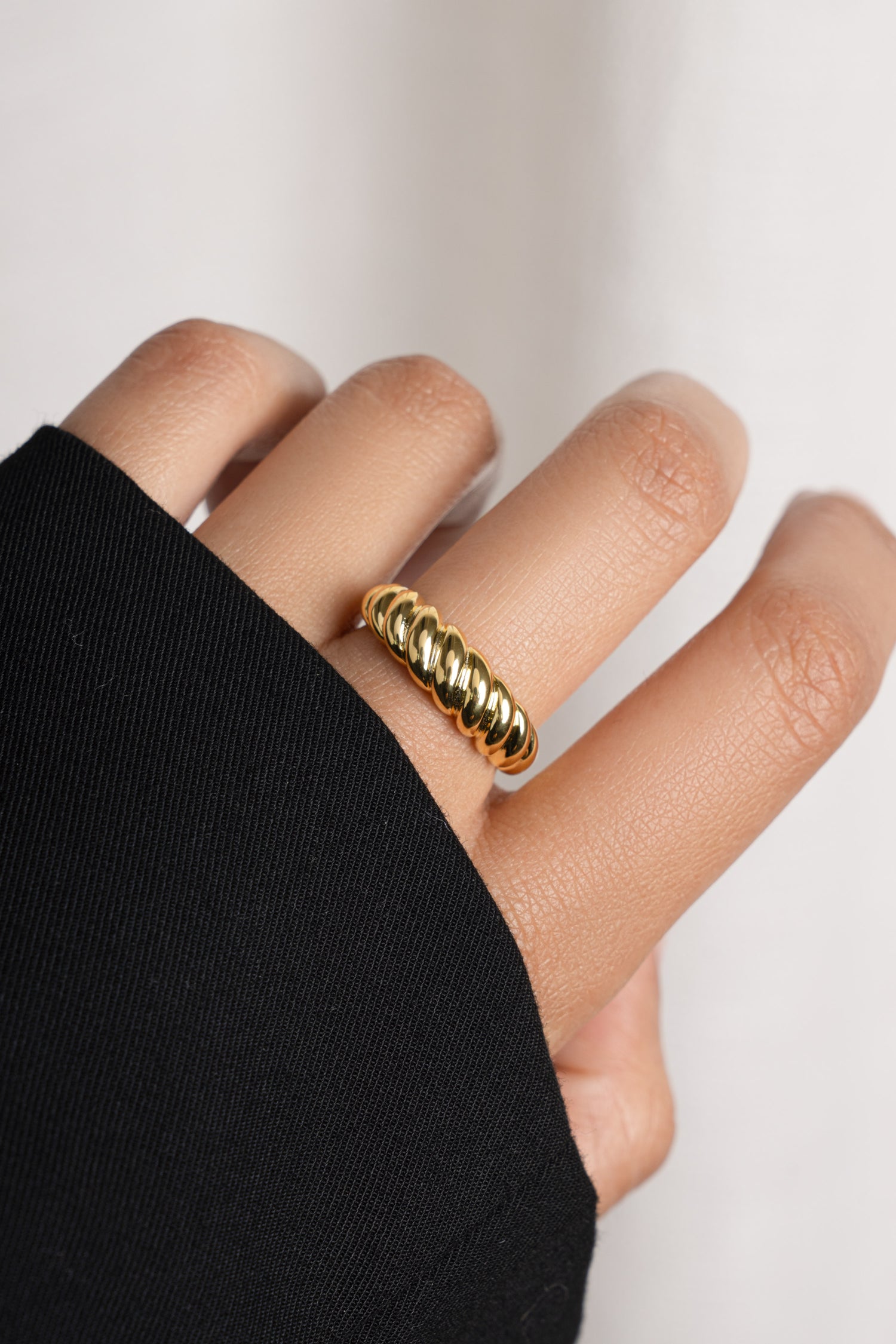 Model wearing gold chunky statement croissant ring.
