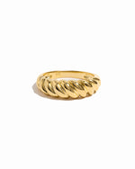Gold croissant ring on white background.
