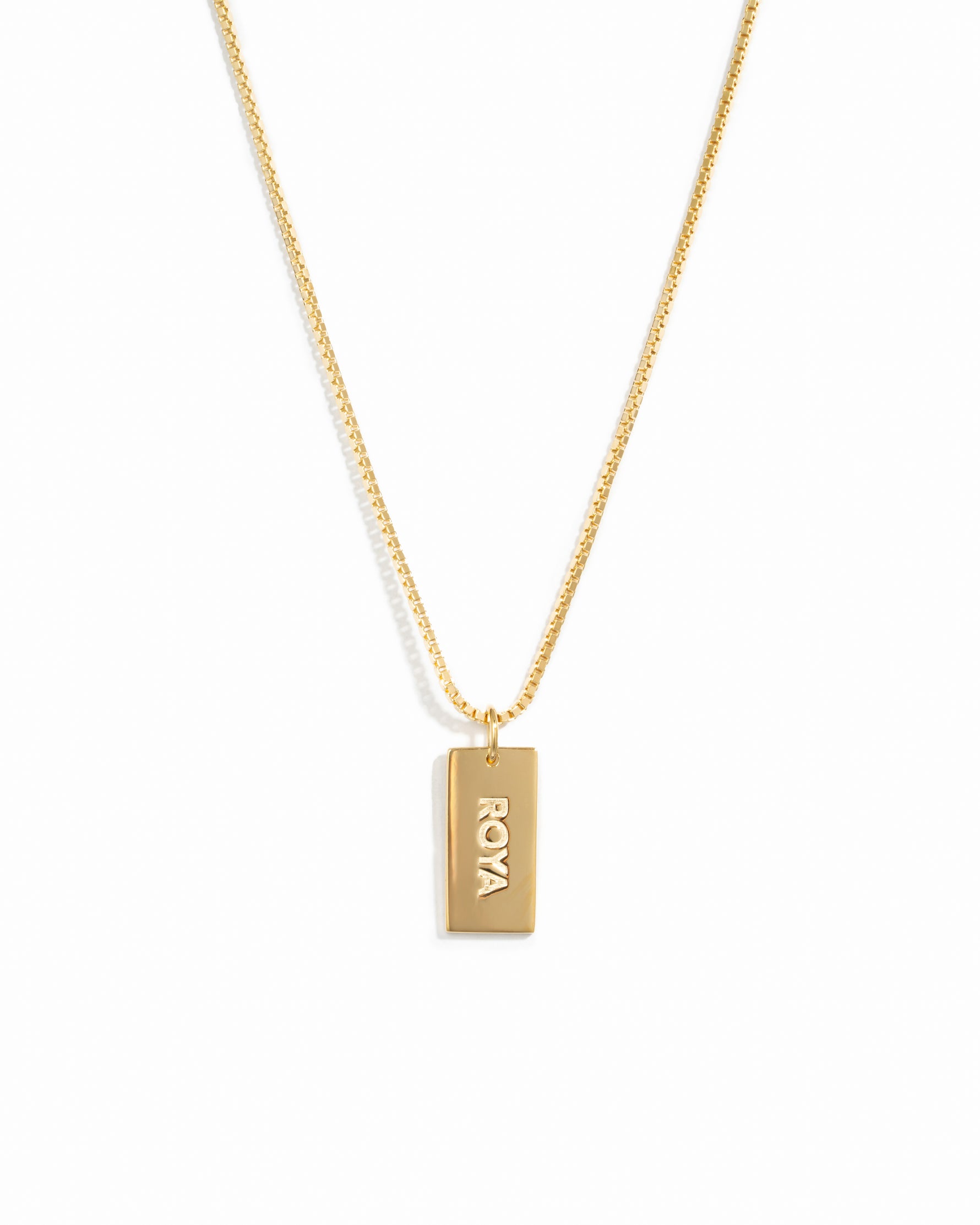Gold dainty dog tag customizable necklace on a box chain with a name on it.