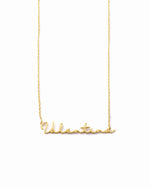 Gold custom script name necklace with a dainty chain on white background