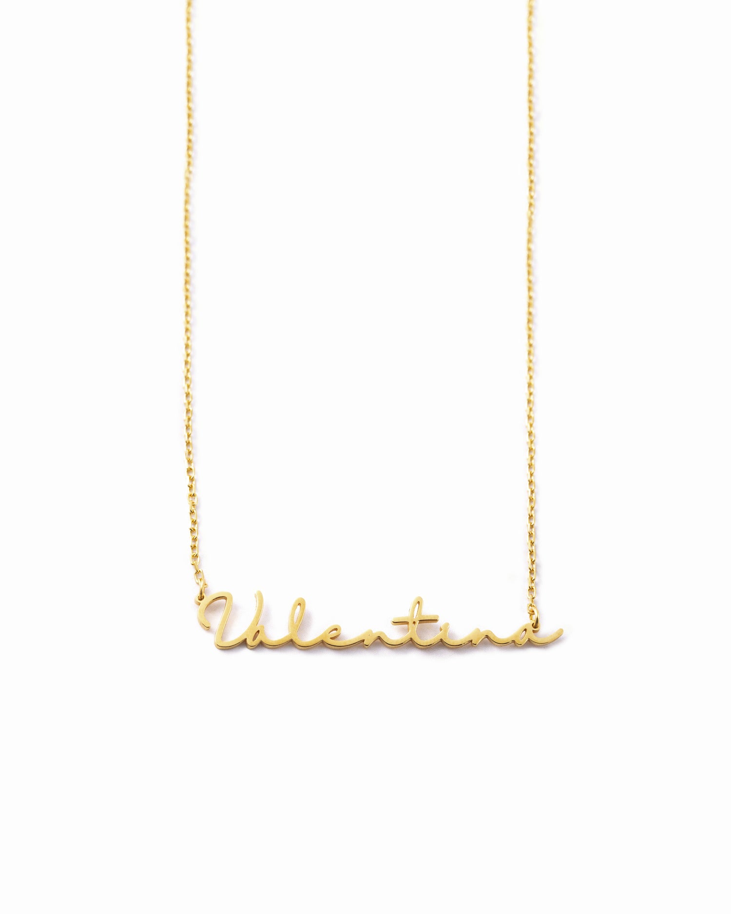Gold custom script name necklace with a dainty chain on white background