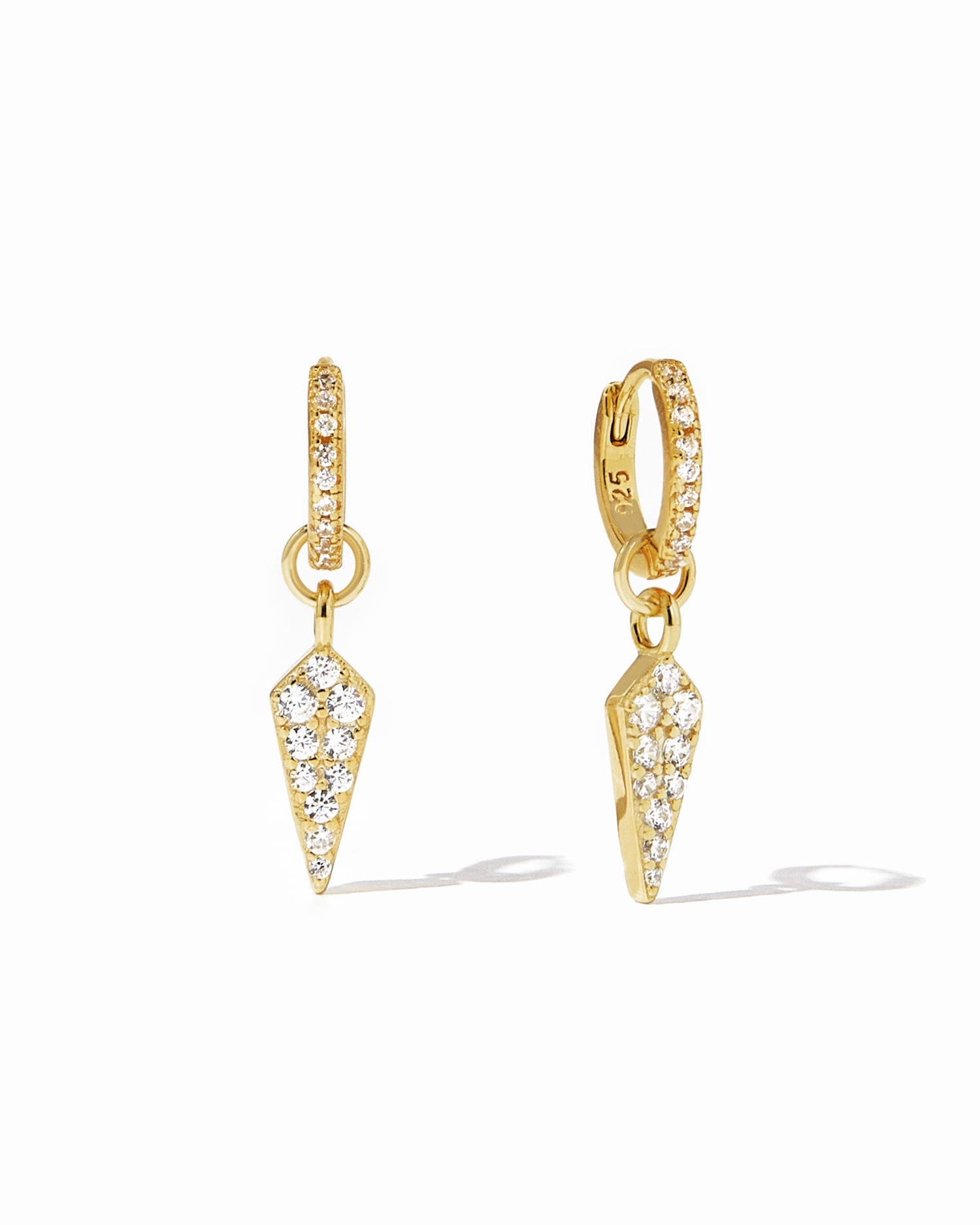 Delicate gold CZ dagger charm huggies with removable charm on white background.