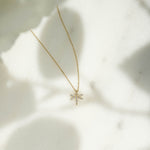 Flat lay of dainty gold dragonfly pendant necklace. 
