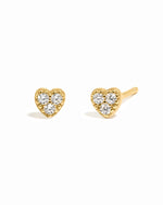 Gold delicate cz studded heart stud earrings on white background.