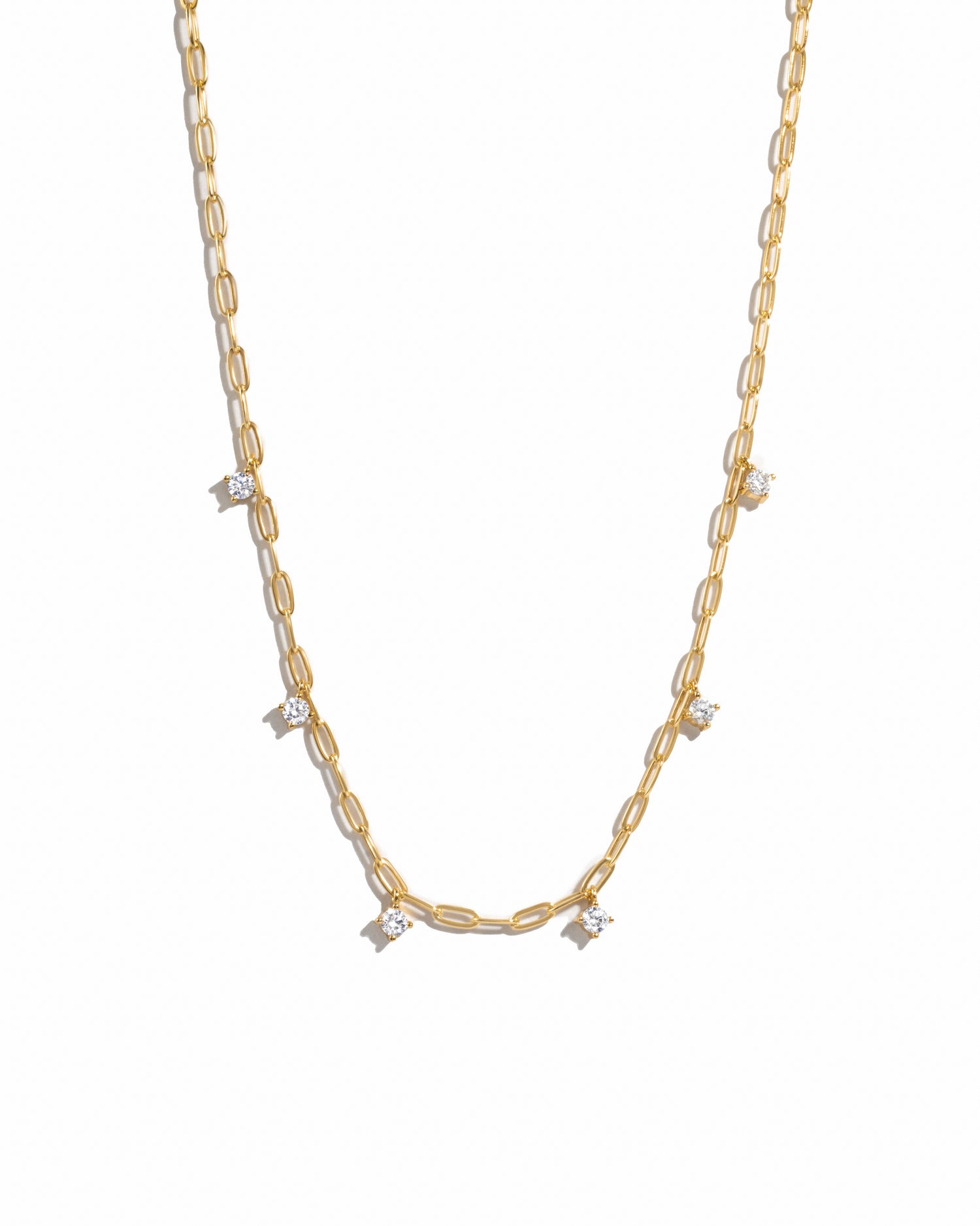 Dainty layering gold paperclip cz charm necklace on white background