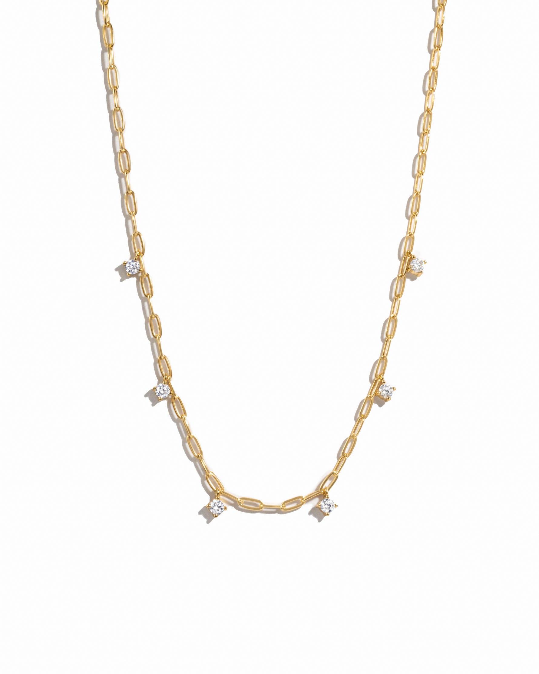 Dainty layering gold paperclip cz charm necklace on white background