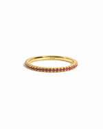 Ruby gemstone eternity band on white background.