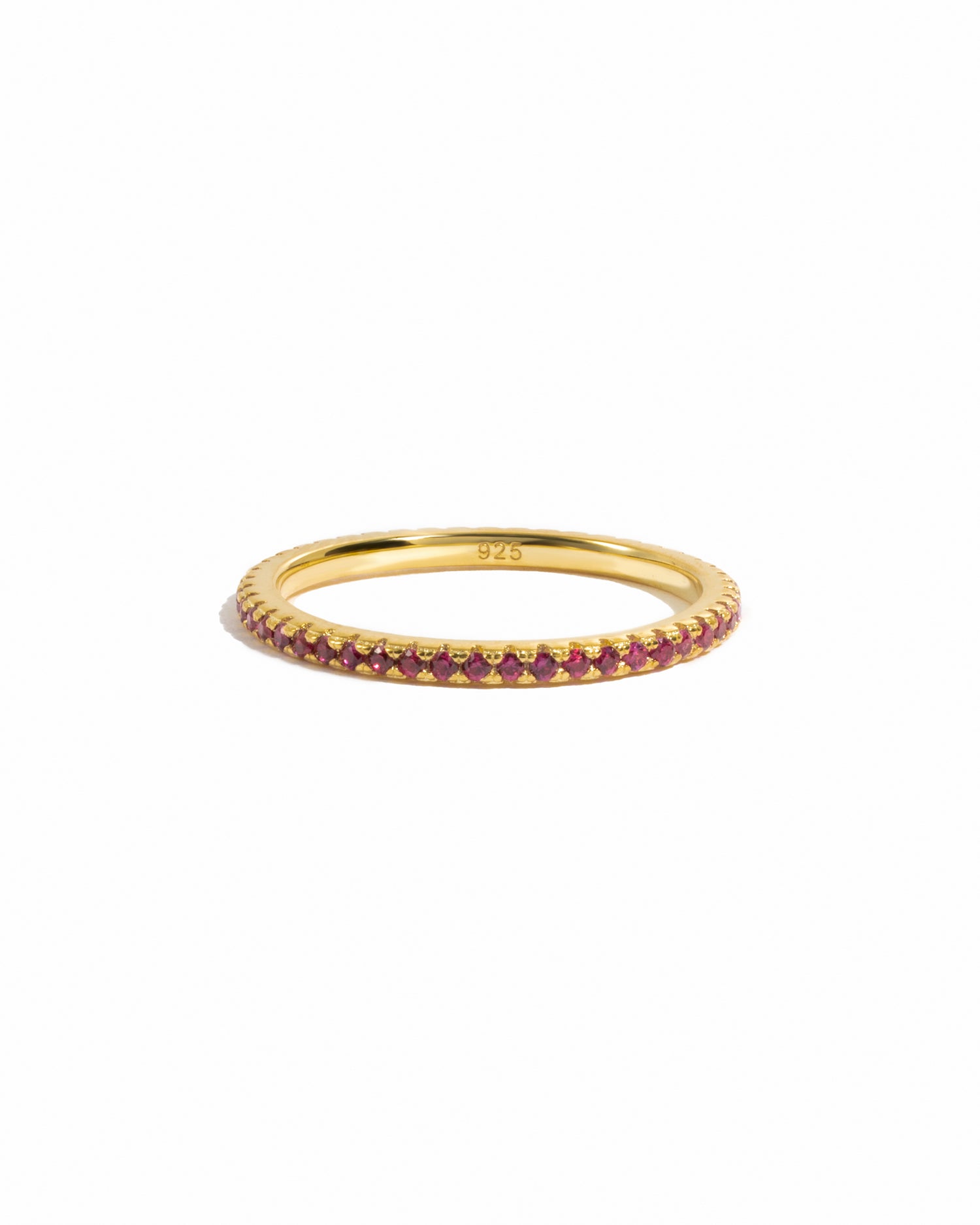 Ruby gemstone eternity band on white background.