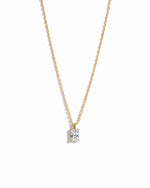 gold diamond emerald cut necklace on white background