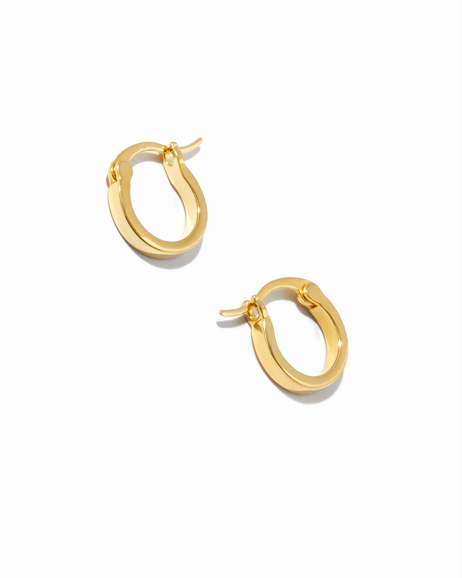 Dainty small 8mm thin flat hoop earrings in gold on white background.