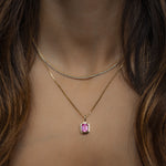 model wearing gold 2mm tennis necklace and pink pendant necklace