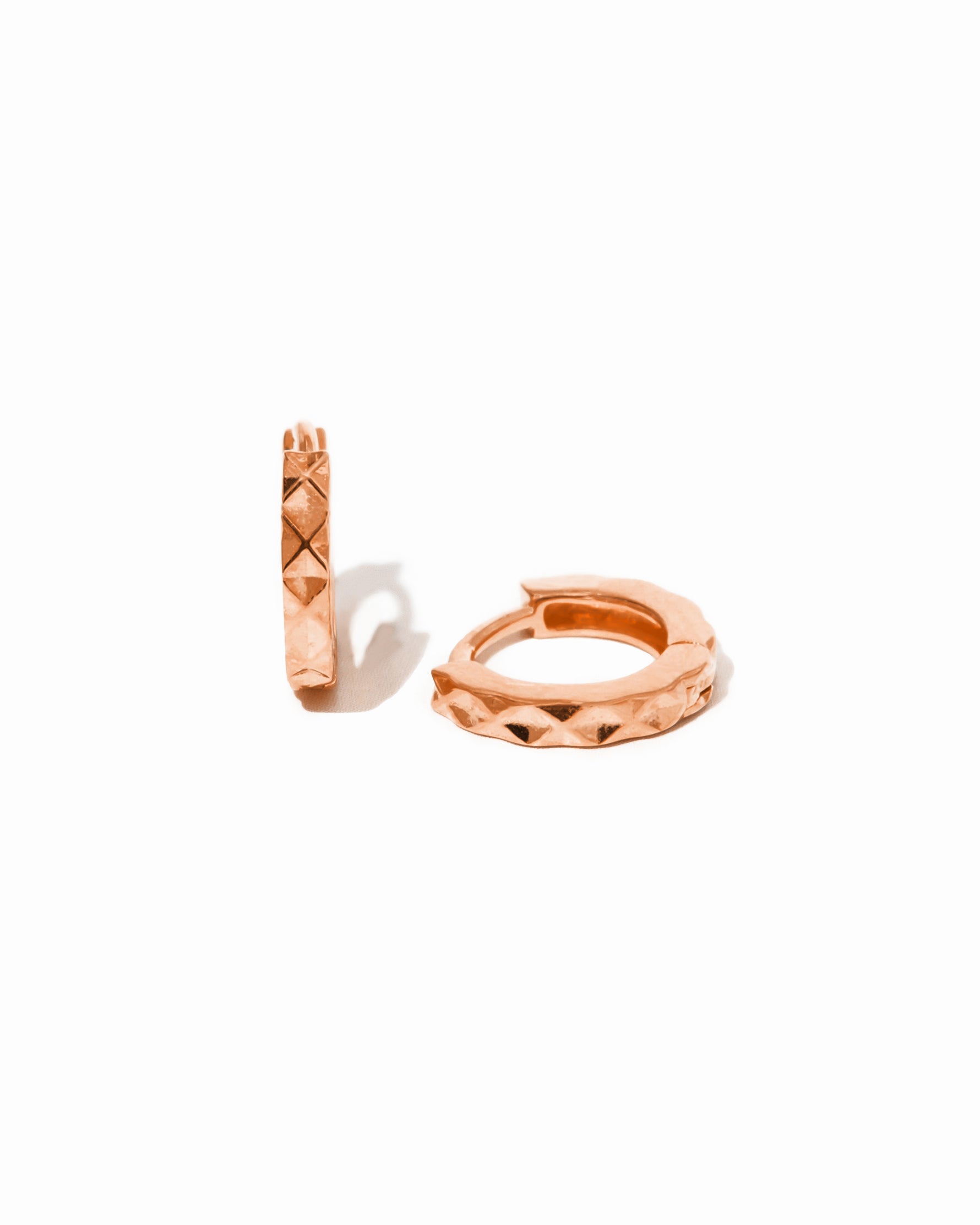Pair of rose gold hoop earrings on a white background