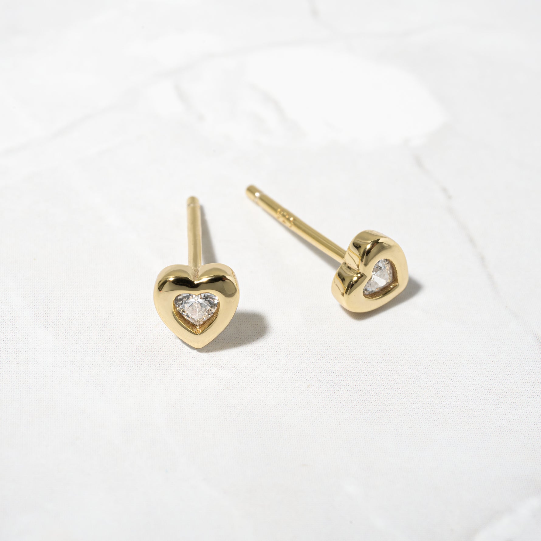 Upclose image of gold diamond heart studs