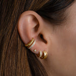 Model wearing gold plain and cz ear cuffs with hoop earrings. 