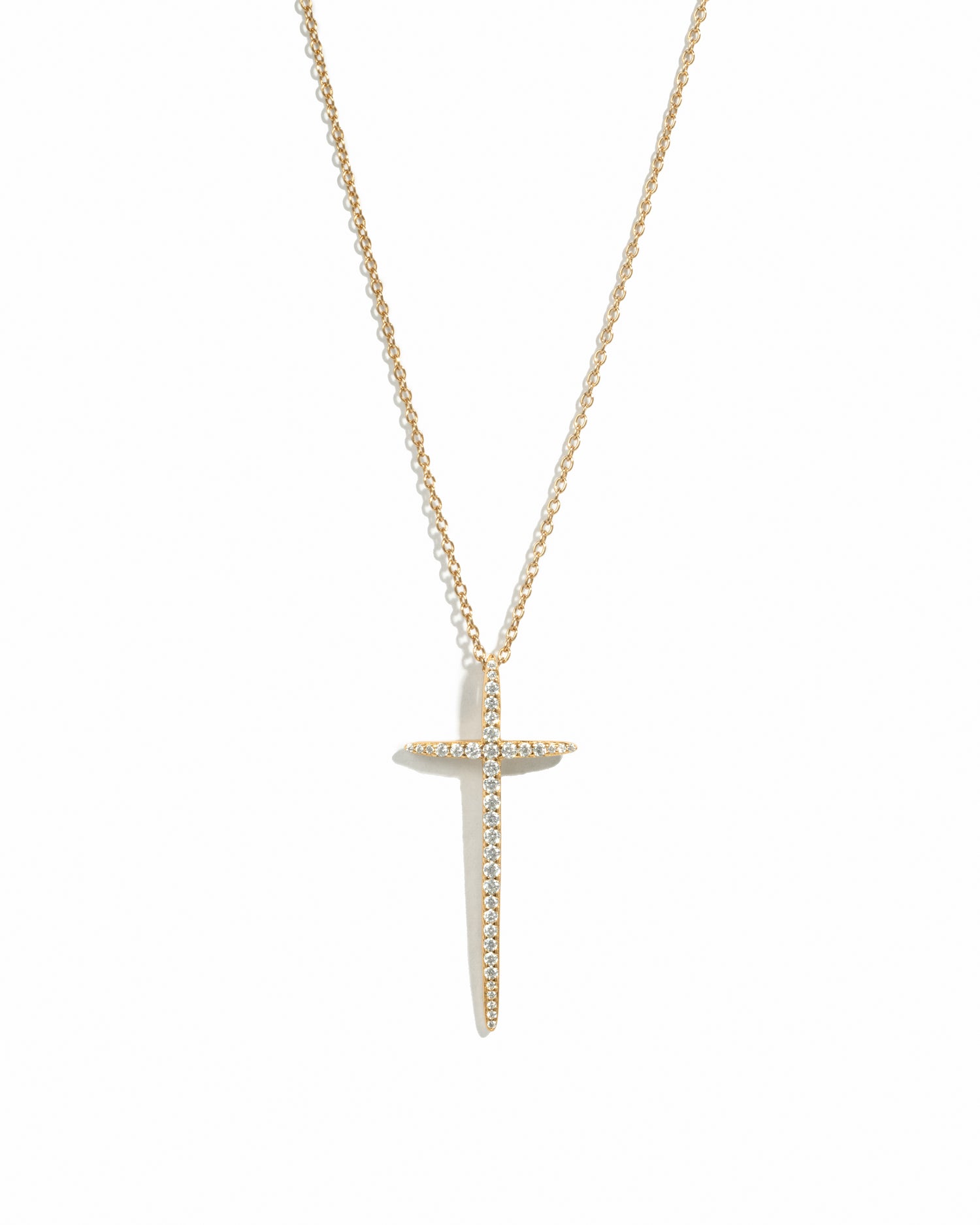 Minimalist large gold cross necklace on white background