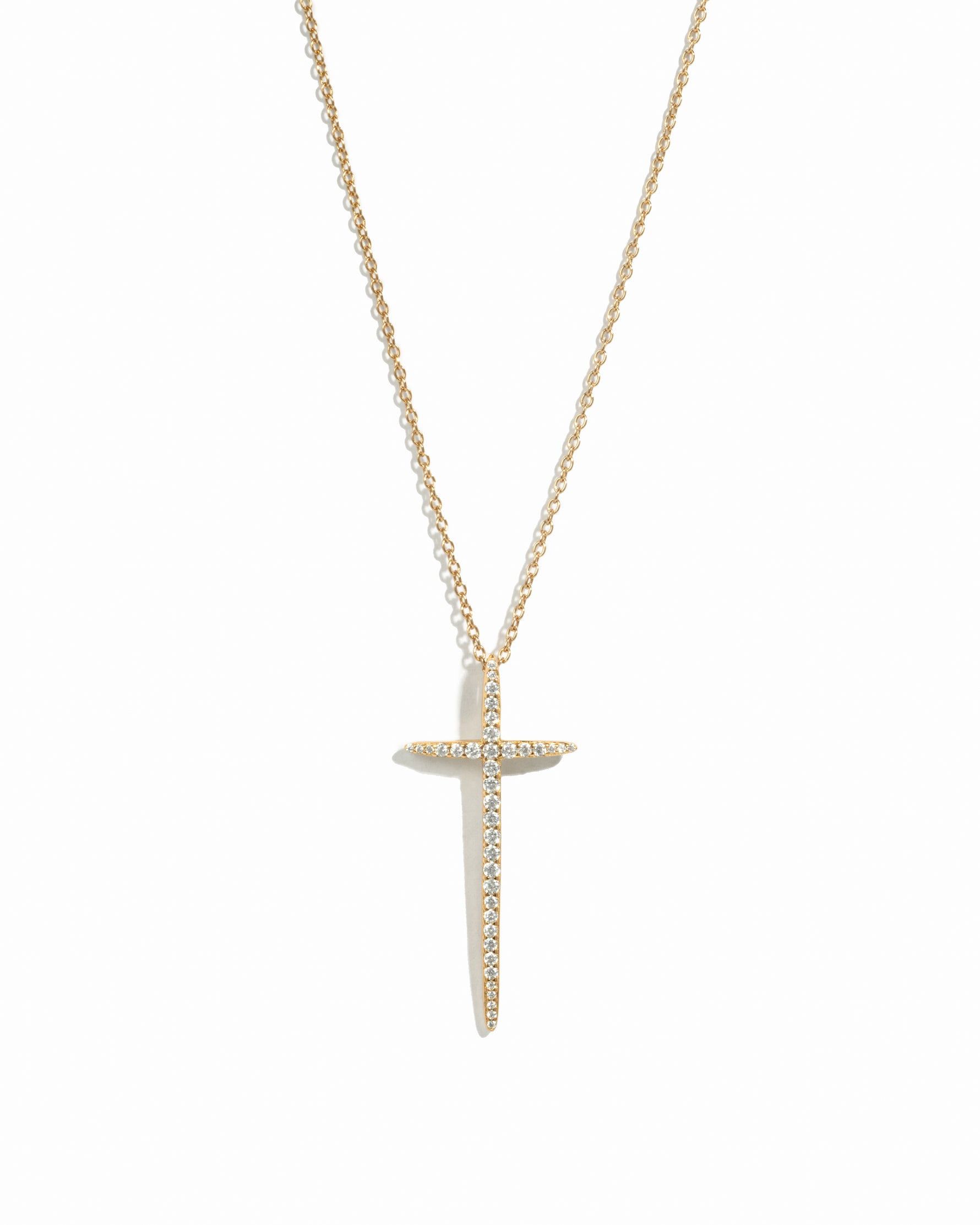 Minimalist large gold cross necklace on white background