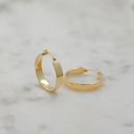 Gold flat hoop earrings.
