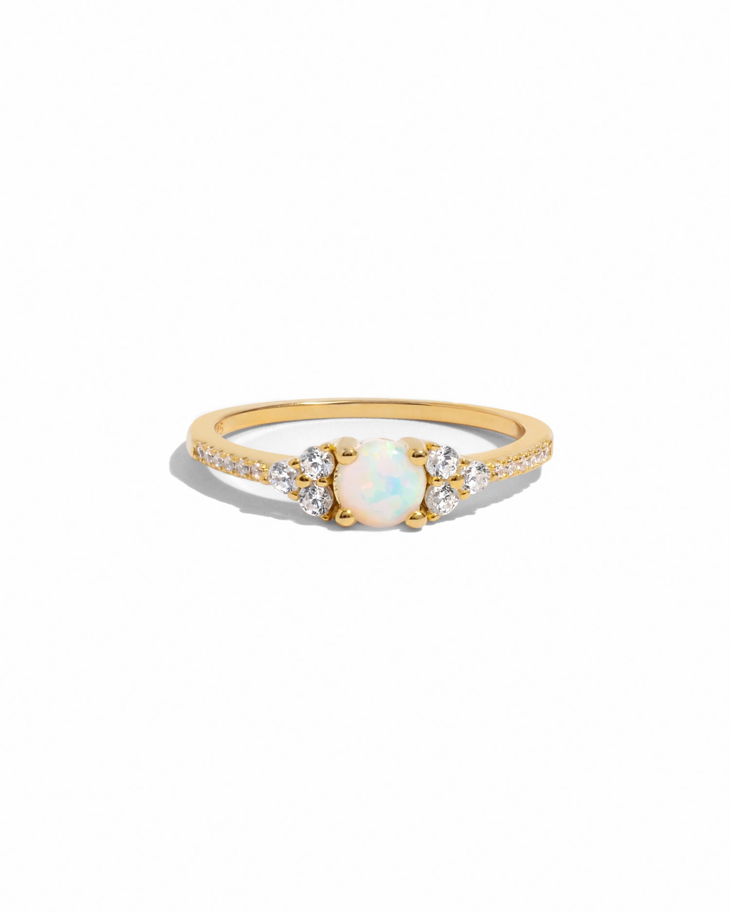 Dainty gold opal stone cluster ring on white background.