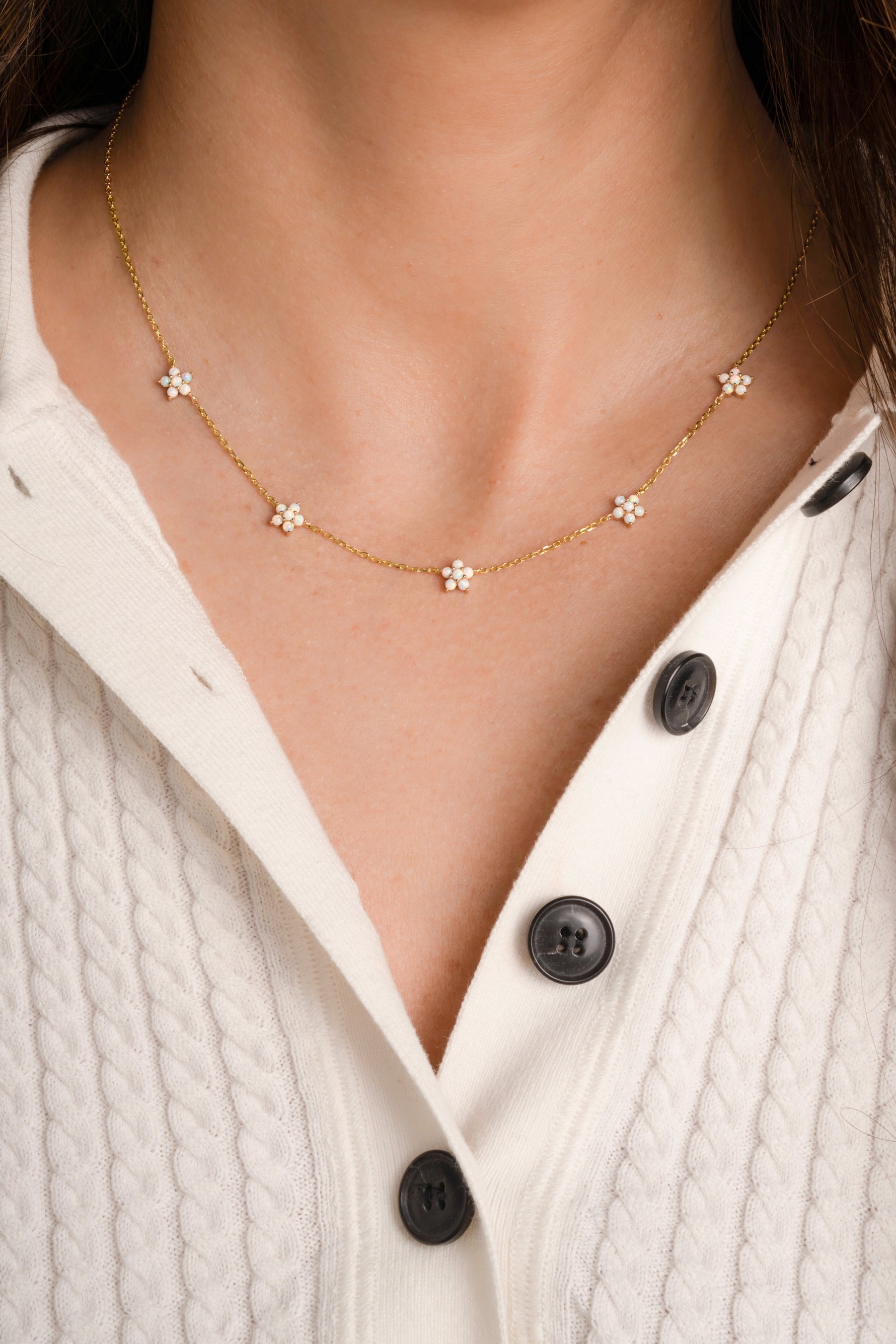 Model wearing diamond flower charm necklace.