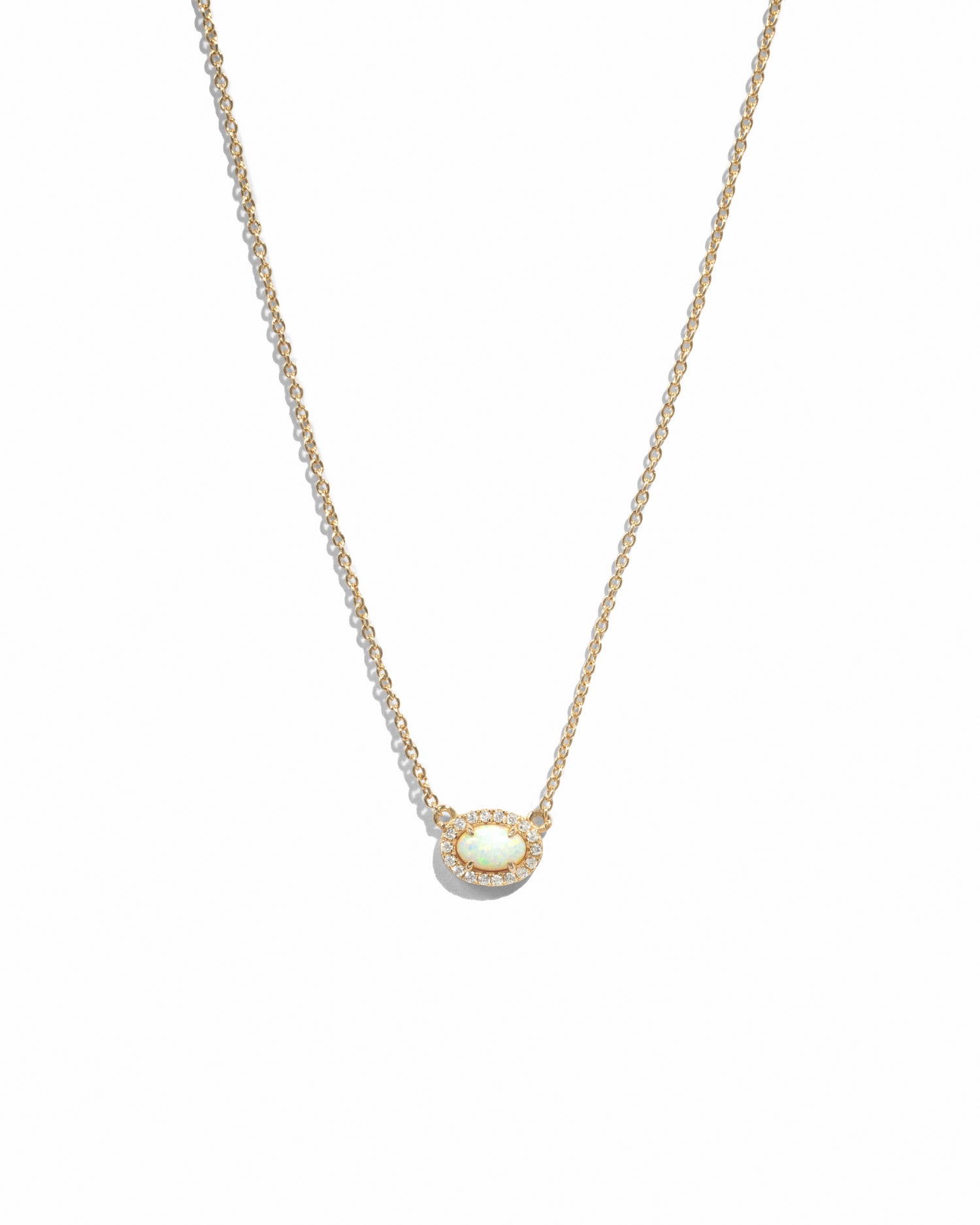 Delicate gold chain with opal oval halo pendant on white background