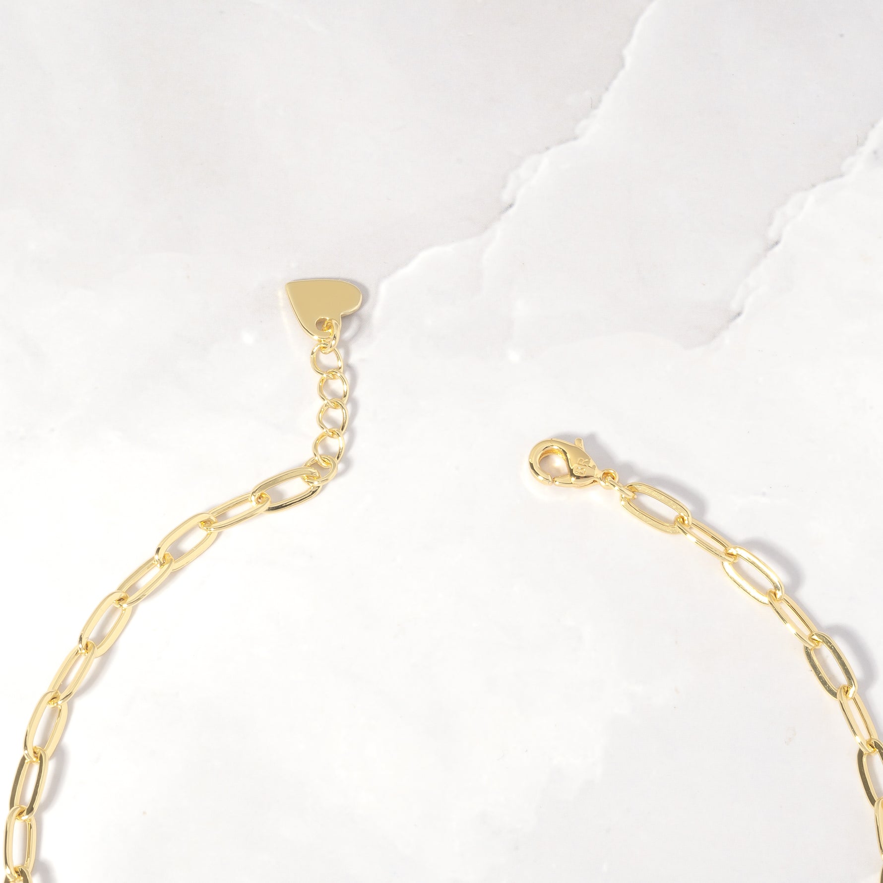 Closeup image of small gold paperclip chain with lobster claw clasp