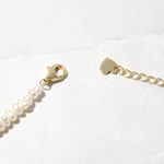 Up-close of gold pearl beaded necklace with lobster clasp. 