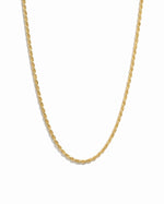 Thin gold rope chain on white background