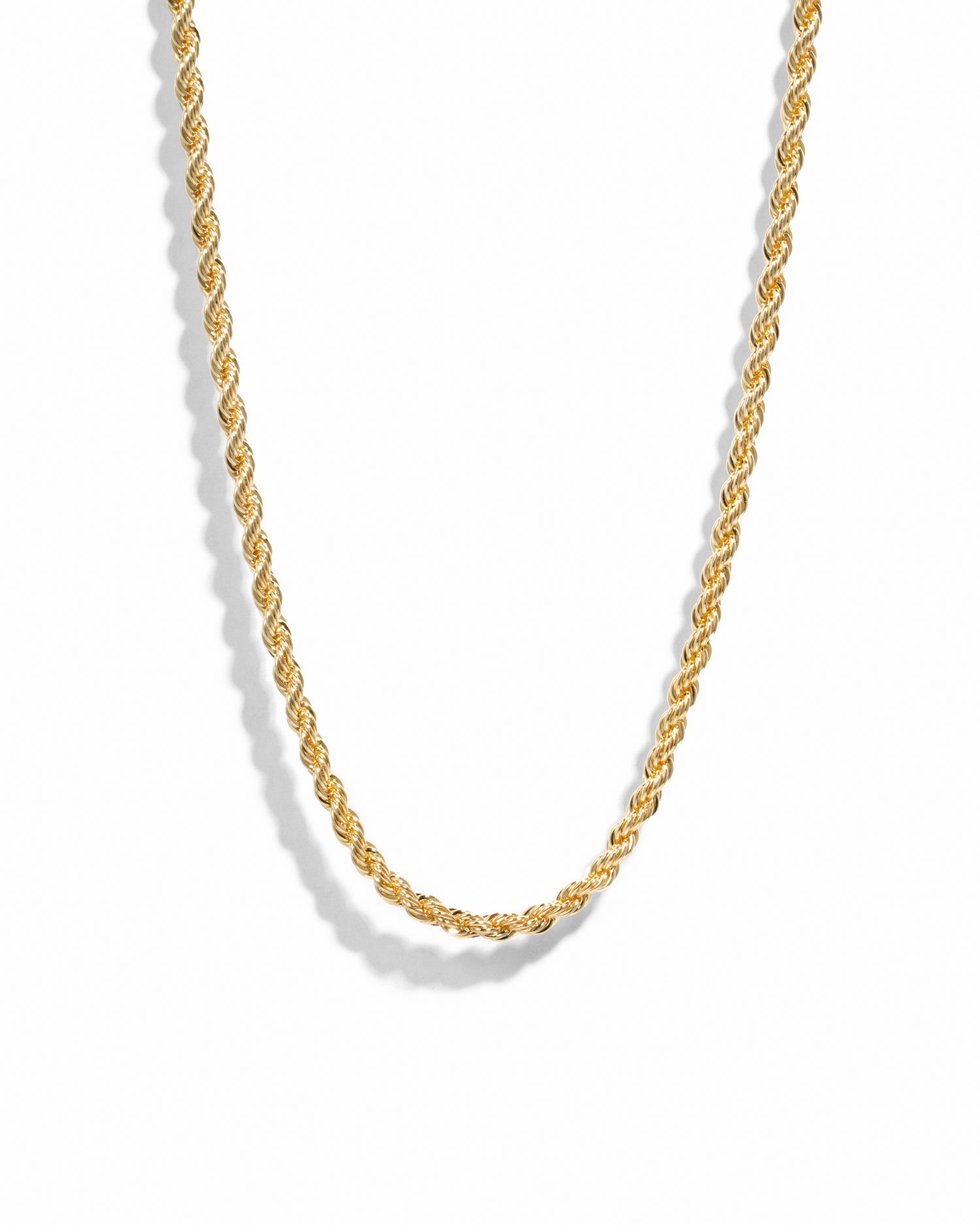 Gold rope chain necklace on white background.