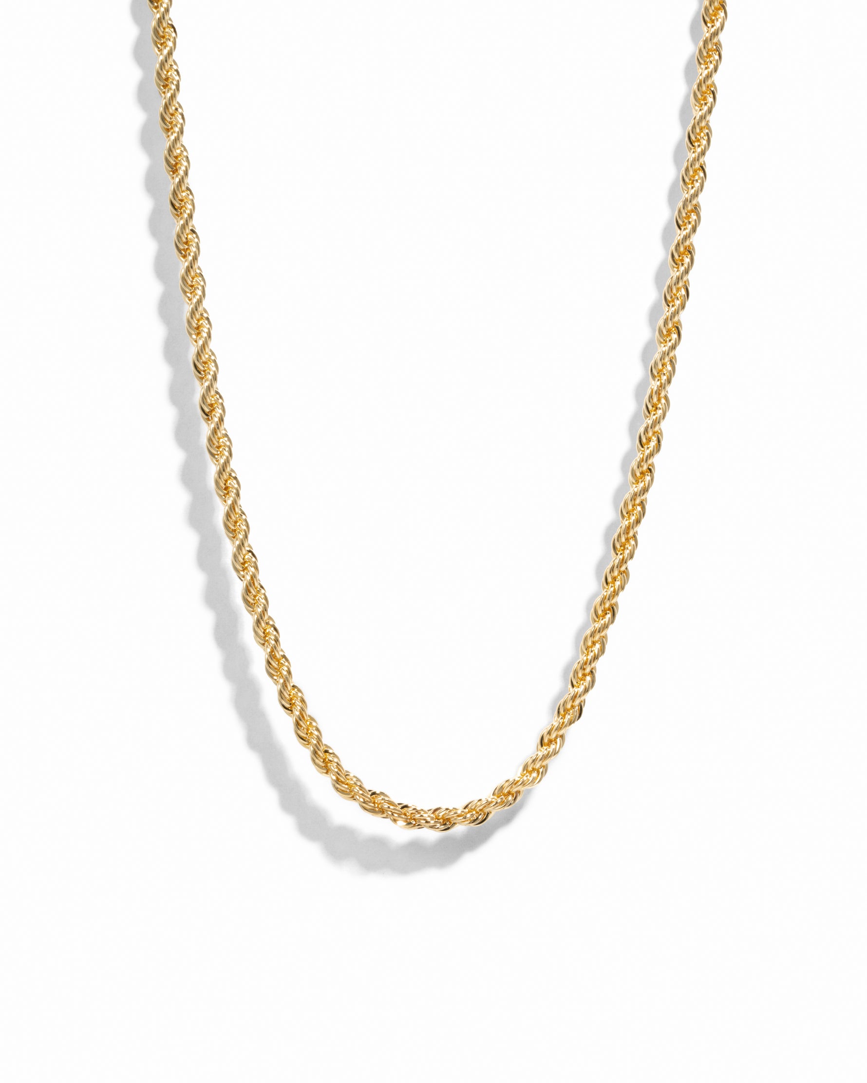 Gold rope chain necklace on white background.