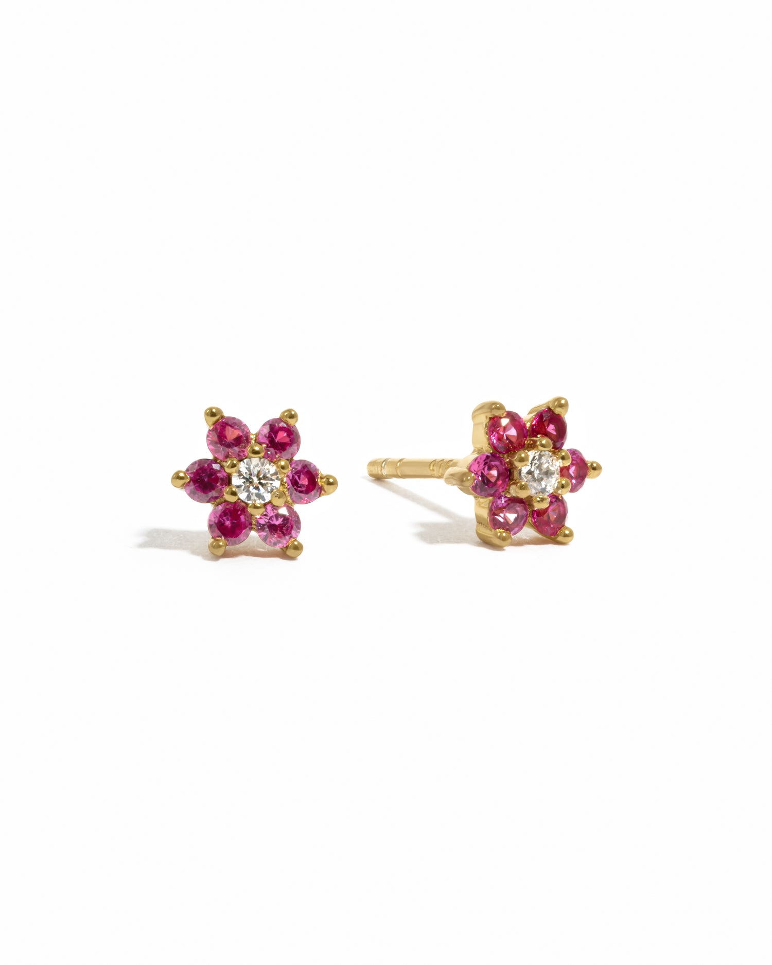 Gold ruby birthstone flower stud earrings with diamond center. 