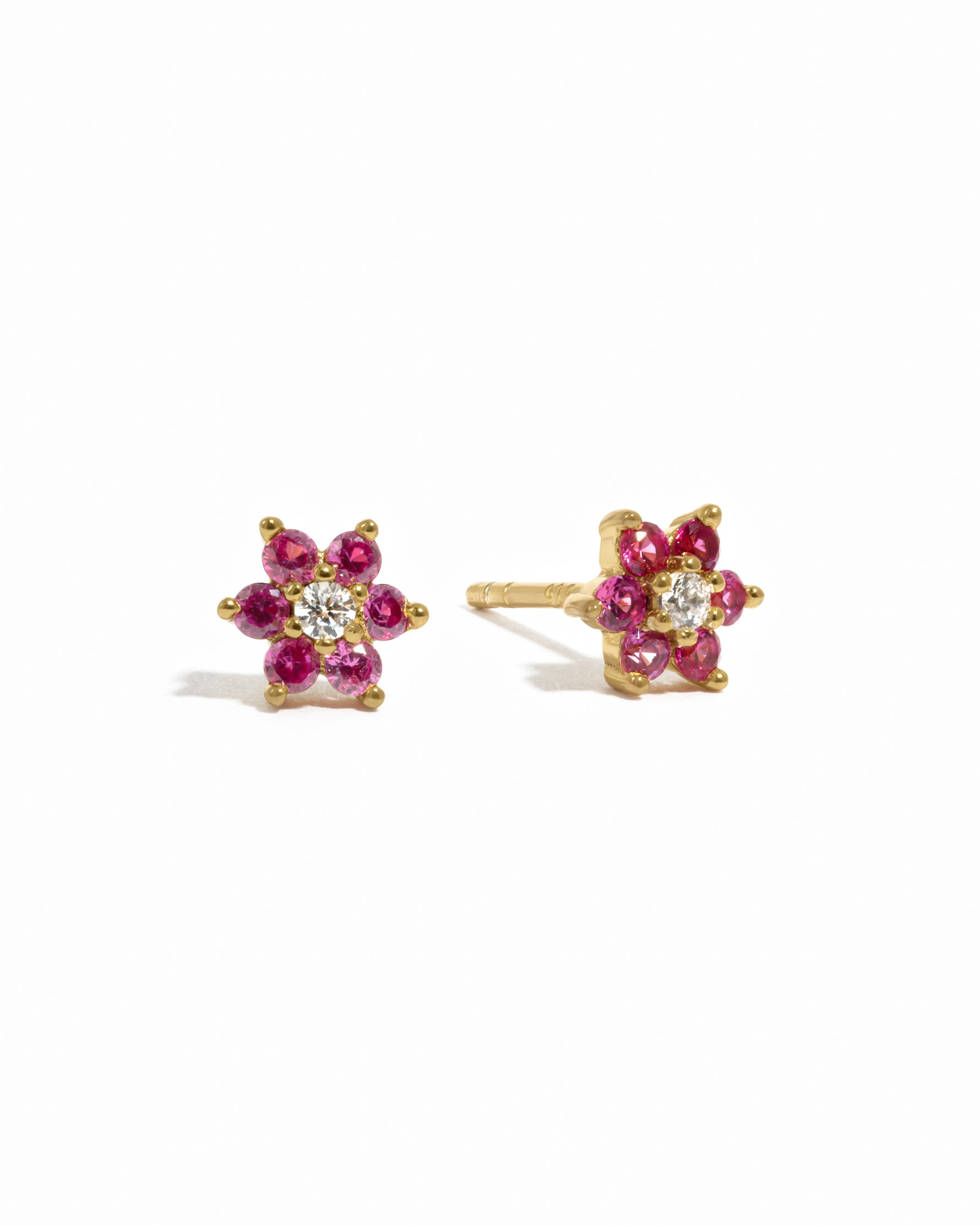 Gold ruby birthstone flower stud earrings with diamond center. 