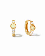 Close up image of gold studded cz baby huggie earrings. The aesthetic opal earrings feature cz diamonds with a solitaire opal stone. 