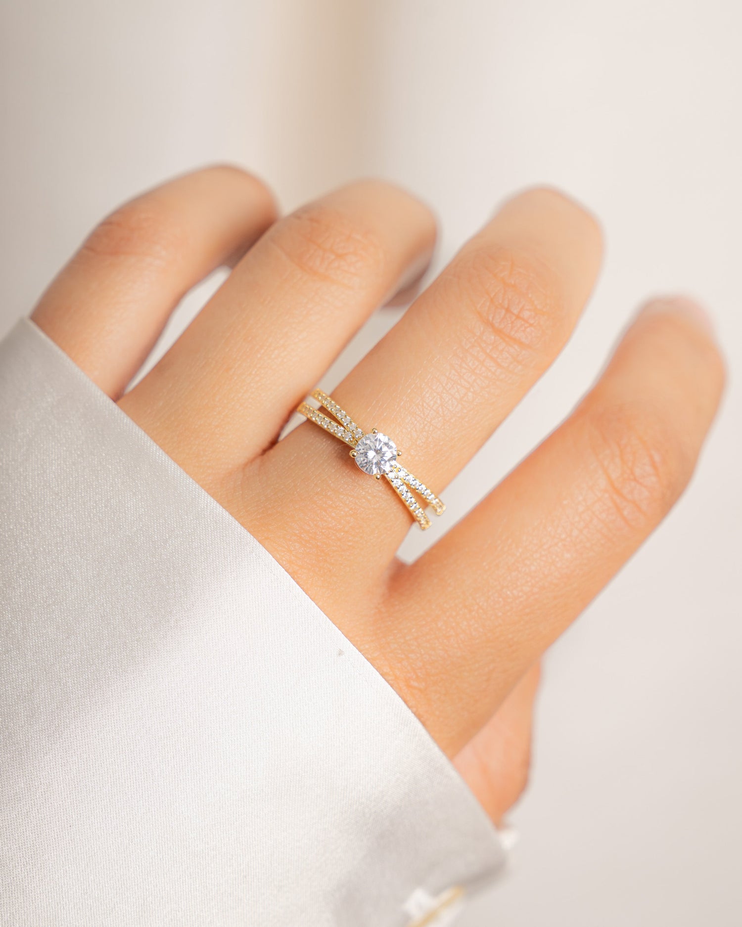 Model wearing elegant gold solitaire diamond ring with studded cz band. 