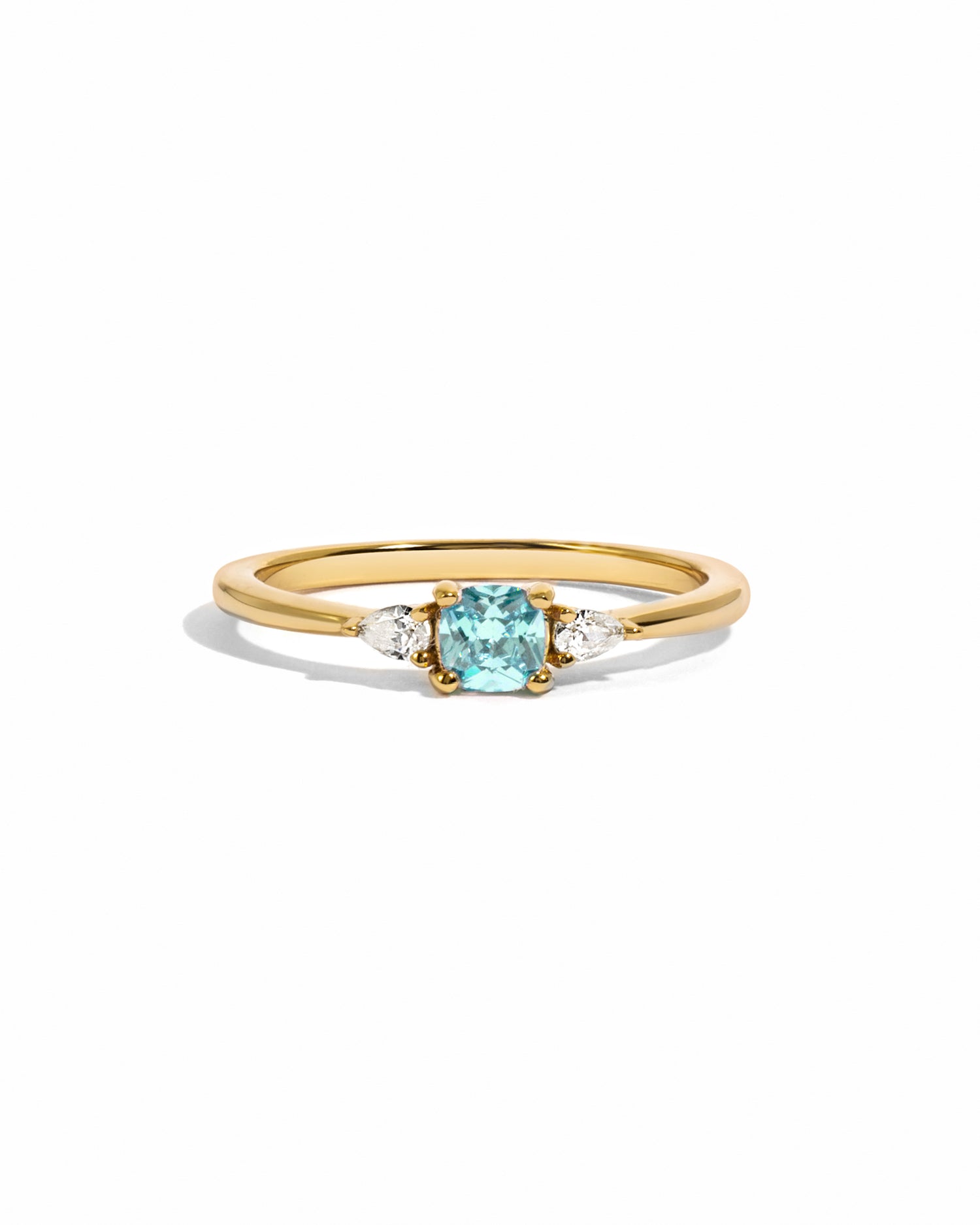 Aquamarine cushion diamond ring on white background in gold.
