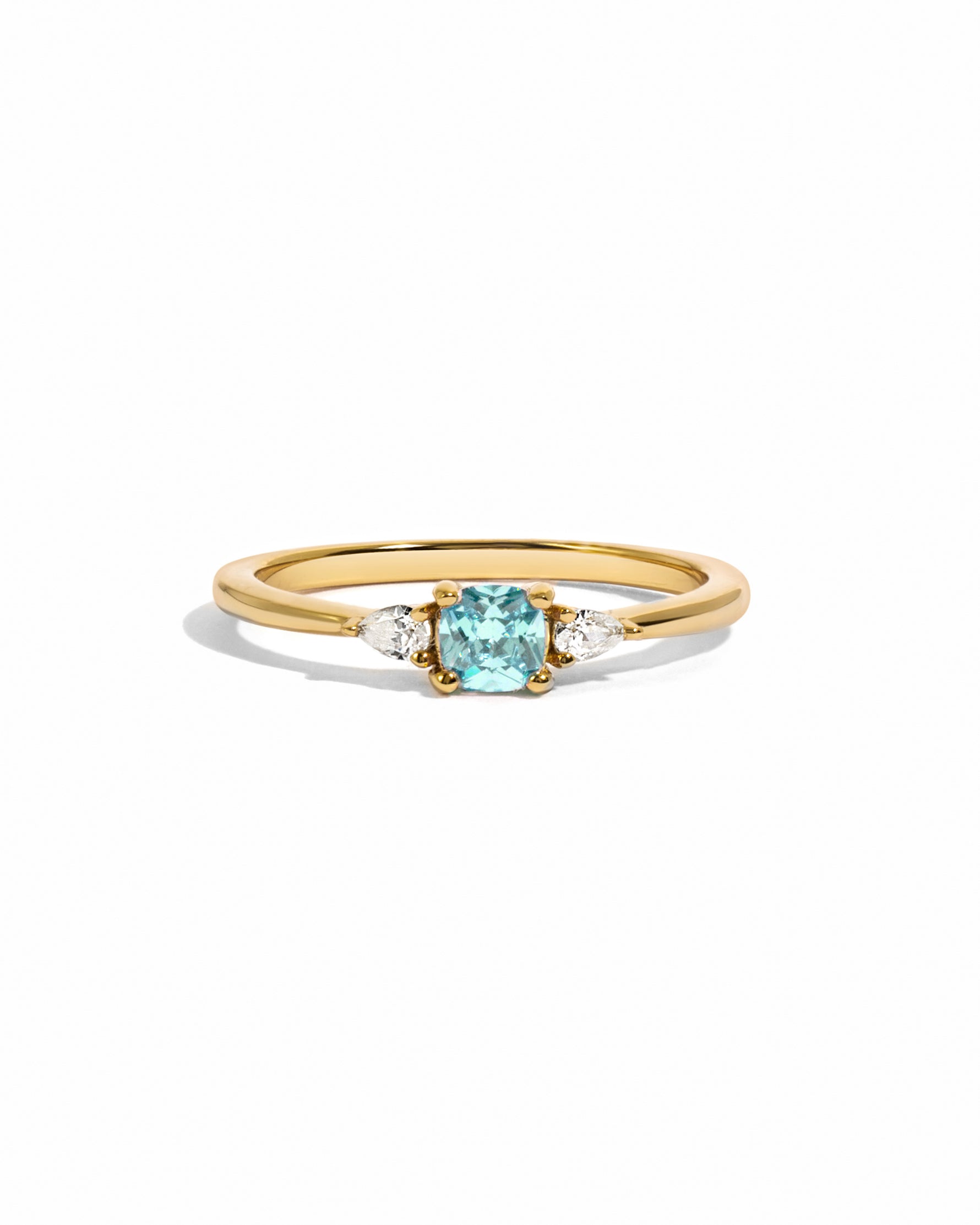 Aquamarine cushion diamond ring on white background in gold.